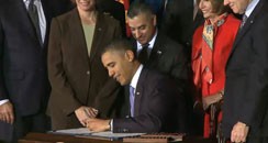 Eric Alva stand behind President Obama while he signs the repeal of Don't Ask, Don't Tell in 2010. (Photo: White House.gov)